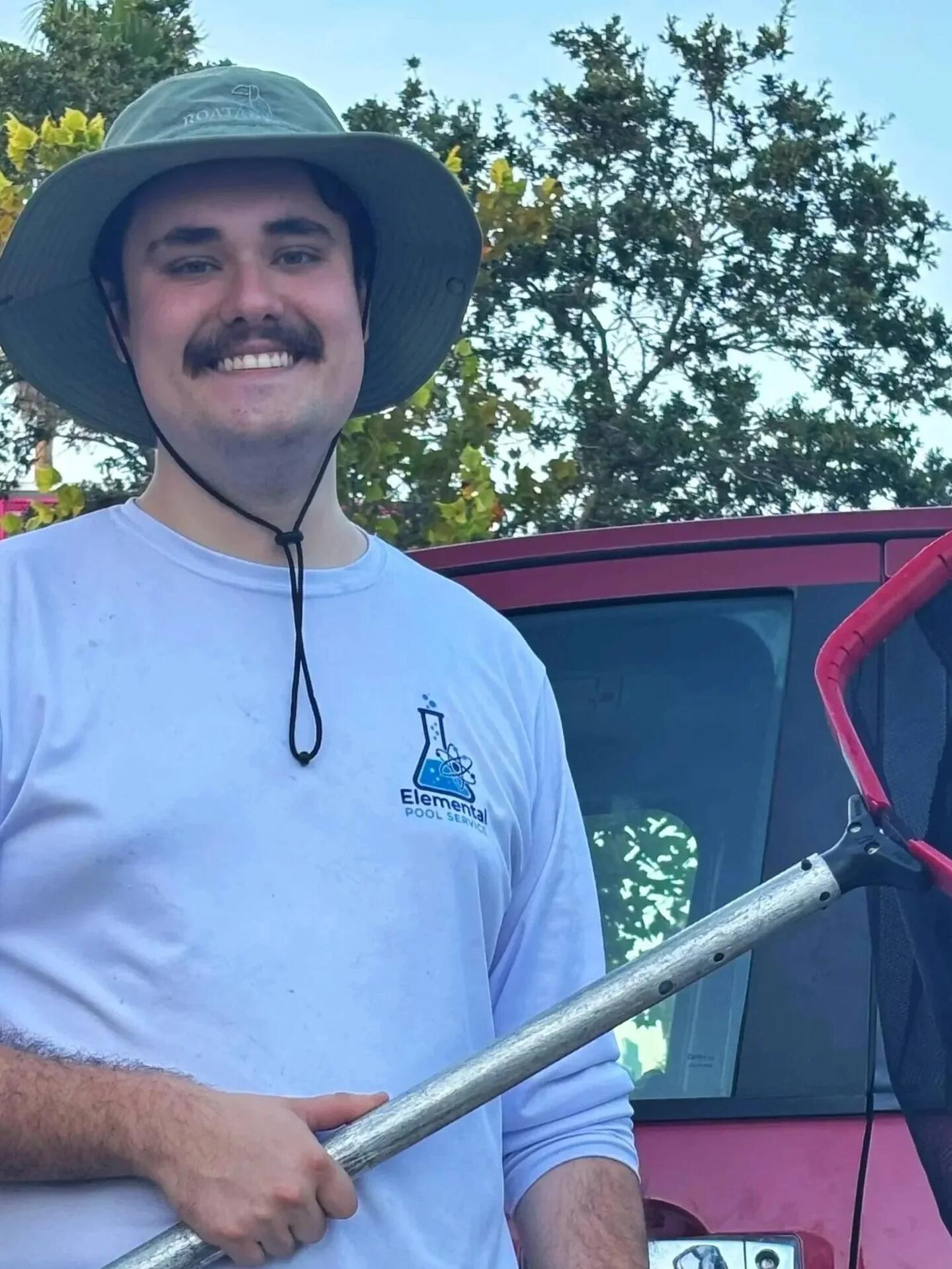 Jason, owner of Elemental Pools in East Orlando, holding a pool skimmer